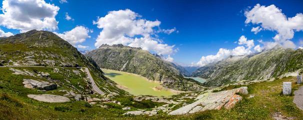 Fototapeta na wymiar Grimselpass in Switzerland, with the road leading down to the la