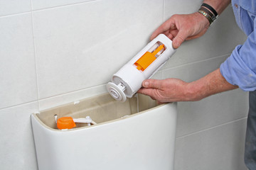 Plumber repairing a toilet cistern