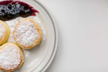 Food photo. Plate of fresh cheese pancakes with icing sugar. Breakfast. Sweet dessert. Curds fritters on a white dish.  Cheese cake. Cottage cheese.