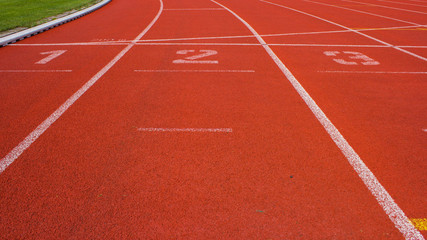Rote Tartanbahn mit Startnummern in einem Station