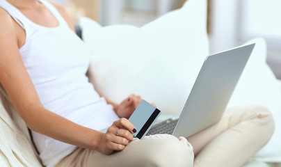 Woman shopping online with credit card and computer.