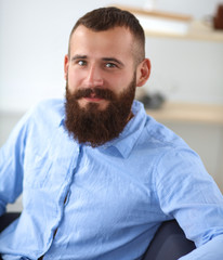 Fototapeta premium Young businessman sitting on chair in office