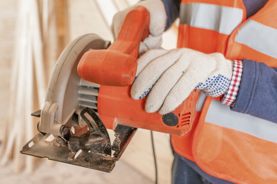 Gloved Hands Holding A Power Tool