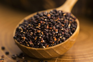 Black quinoa seeds on a wooden background