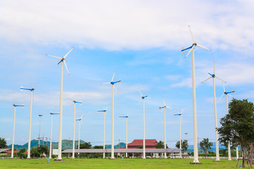 Fototapeta na wymiar windmill in green field with blue sky
