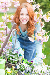 Frau lächelnd beim einpflanzen der Blumen 