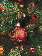 vertical image of christmas tree with bauble and lights.