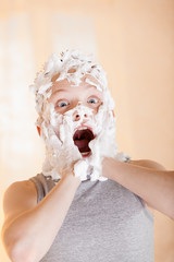 Excited boy with lather on his face hair and hands