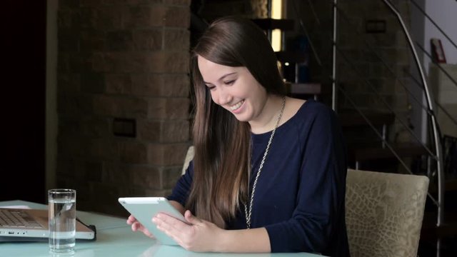 girl sitting at table with pad and laughing