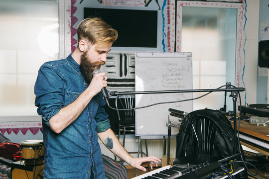 Hipster man singing in a studio