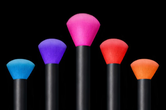 Makeup concept. Colorful Make up brushes over black background