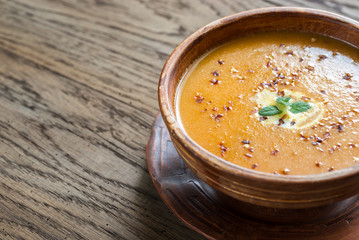 Bowl of spicy pumpkin cream soup on the wooden table