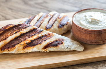 Grilled chicken with tahini sauce on the wooden board