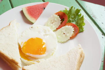 Fototapeta premium Close up fried egg with bread and vegetable with watermelon