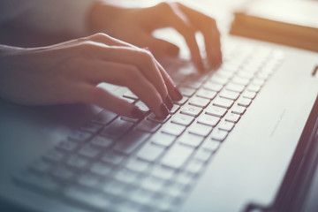 Woman working in home office hand on keyboard close up