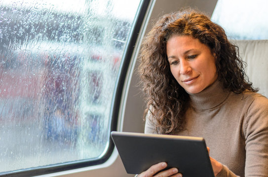 Young woman travelling on a train on a rainy day