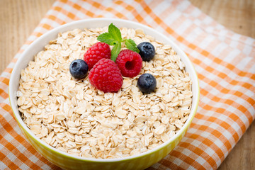 Oatmeal porridge with berries. Raspberries and blueberries.