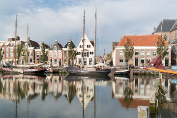 Old houses on quay of Zuiderhaven harbor canal with boats in Harlingen, Friesland, Netherlands
