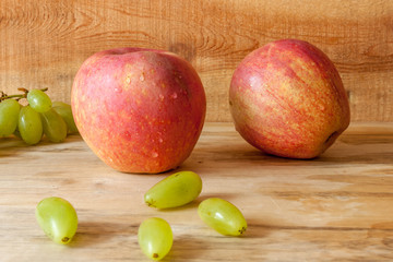 Fresh apples and grapes with wood background