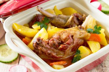 Roasted duck meat with boiled potatoes on a wooden table, select
