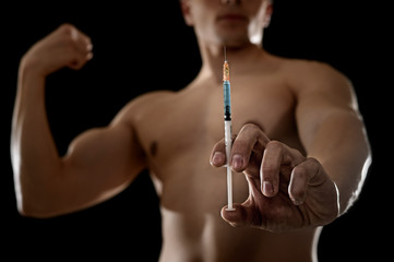 young athletic sportsman holding syringe in sport doping and cheat concept - obrazy, fototapety, plakaty
