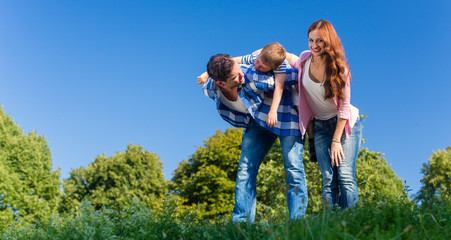 Fototapeta premium Daddy carrying son piggyback on his back