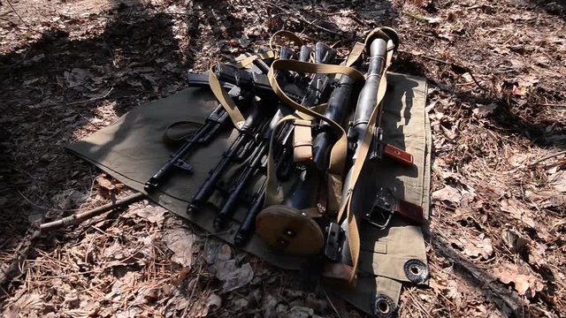 Weapons on the ground. Camera moves back and forth over the guns
