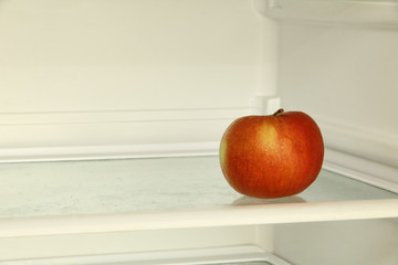 Ripe red apple in domestic refrigerator.
