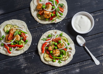 Chicken meatballs and fresh vegetables tortilla on a wooden rustic board. Healthy tasty food