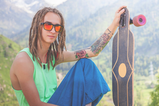 Portrait of cool, funny handsome man with skateboard