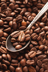 Macro shot of coffee beans in vintage silver spoon