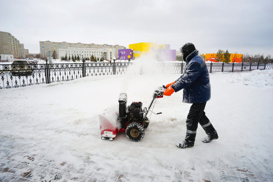 The man works in  courtyard of the snow-removing unit.