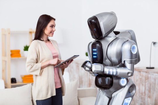 Positive girl standing with the robot 