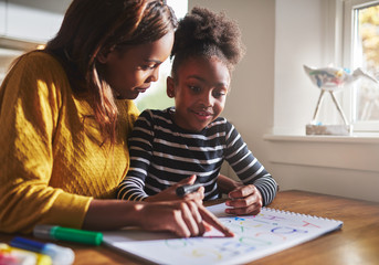Black mother learning her daughter the alphabet
