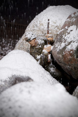 brave toy soldier on snowy rock