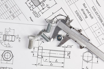 Caliper, bolts and nuts on a background of engineering drawings. Science, mechanics and mechanical...