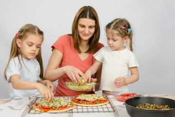 Mom with two young assistants make pizza