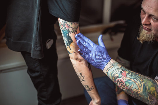 Naklejka master tattooist gets a healing ointment on the skin after the tattooing