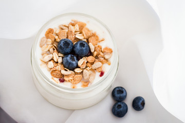 Healthy breakfast - yogurt with blueberries and muesli served in bank