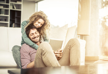 Couple looking tablet at home