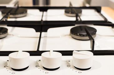 Obraz na płótnie Canvas new white stove with knobs on wooden desk