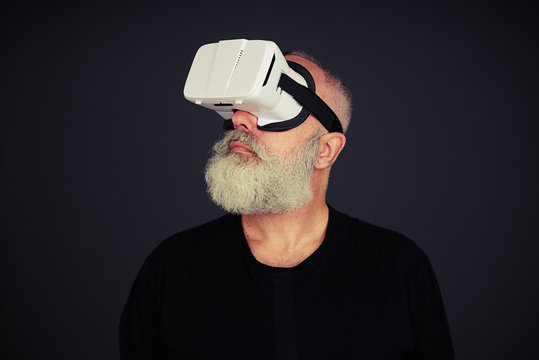 Senior man looking around using virtual reality glasses