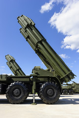 Heavy missile launchers on powerful mobile transportations standing in row ready to attack, modern military industry, antiaircraft forces, blue sky and white clouds on background 