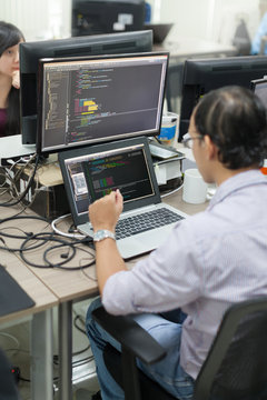 Asian Outsource Software Developer Looking Screen Sitting At Desk