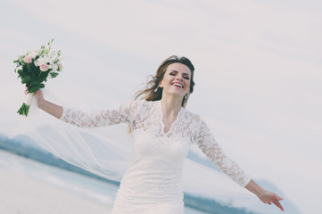 Obraz na płótnie Canvas Happy amazing young woman in wedding dress