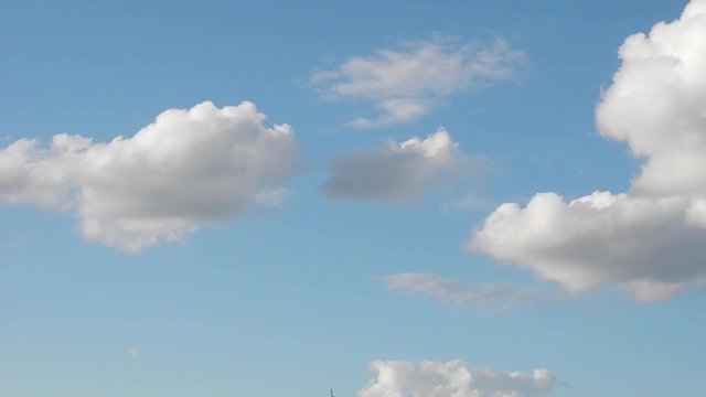 Zeitrafferaufnahme von wei&szlig;en und grauen Wolken, die &uuml;ber den hellblauen Himmel ziehen

