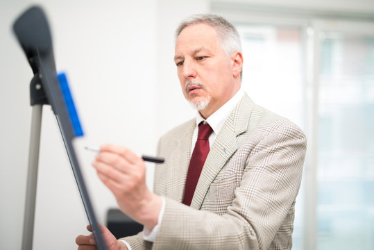 Businessman writing on a white board