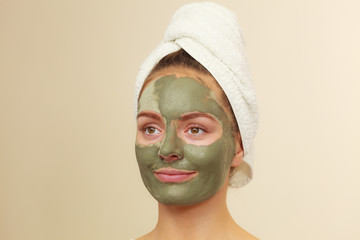Woman face with green clay mud mask