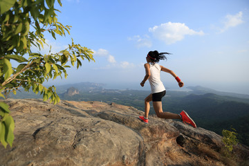 Naklejka premium young asian woman runner running on mountain peak