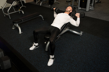 Young Healthy Man Doing Chest Exercise With Dumbbells